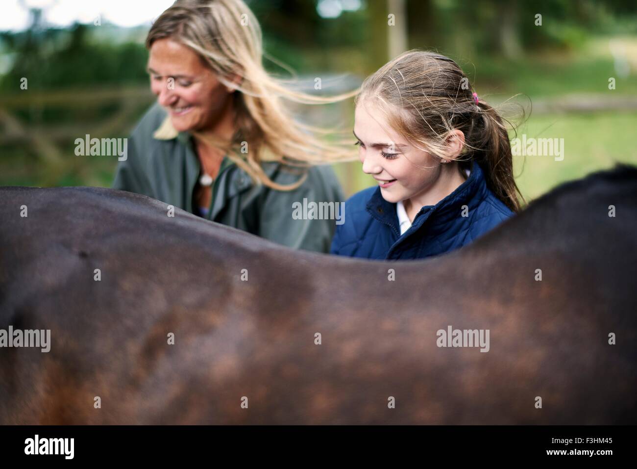 Mädchen und Mutter Pflege Pferd Stockfoto