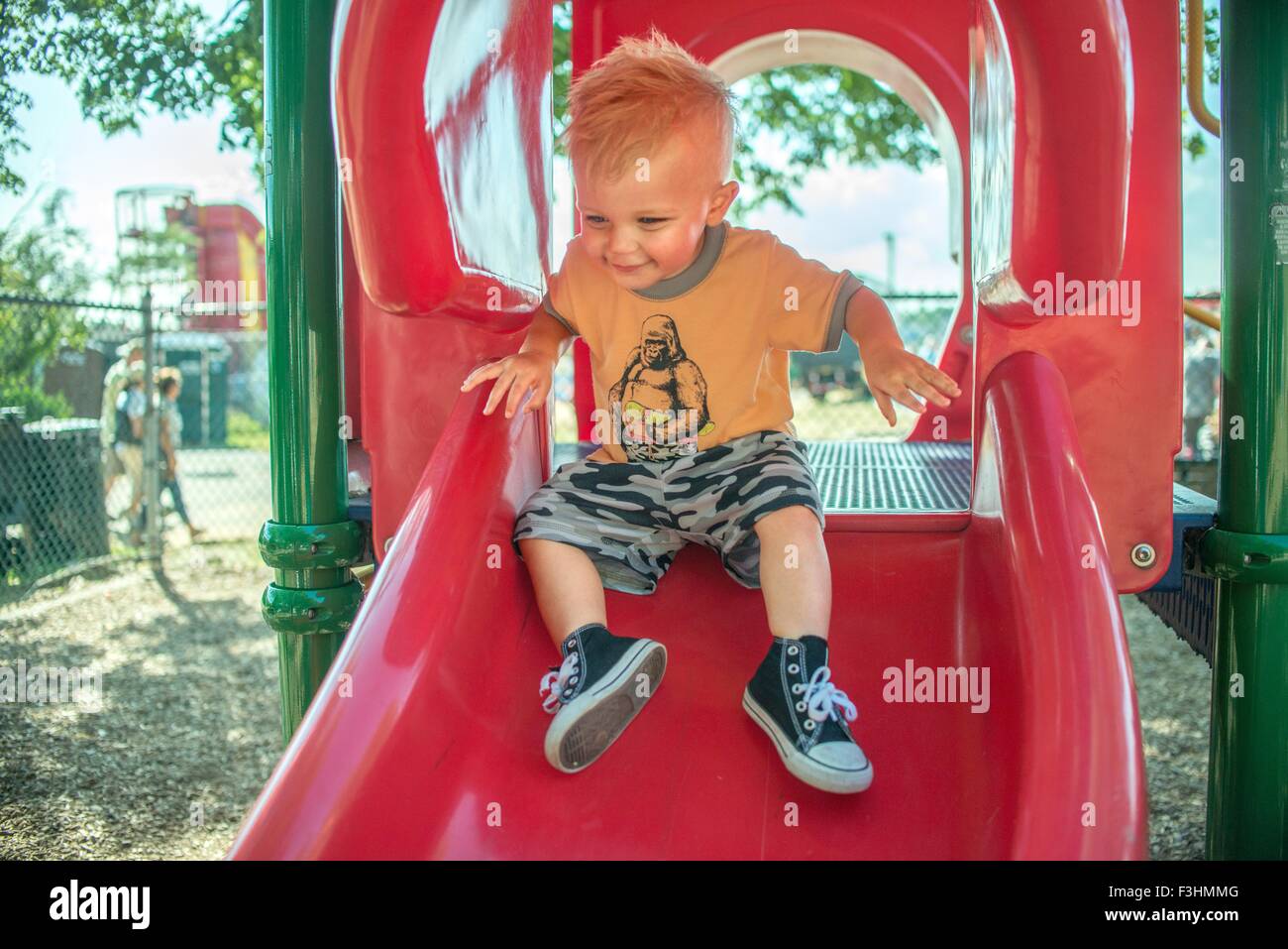 Ein Baby junge spielt auf rote Rutschbahn Stockfoto