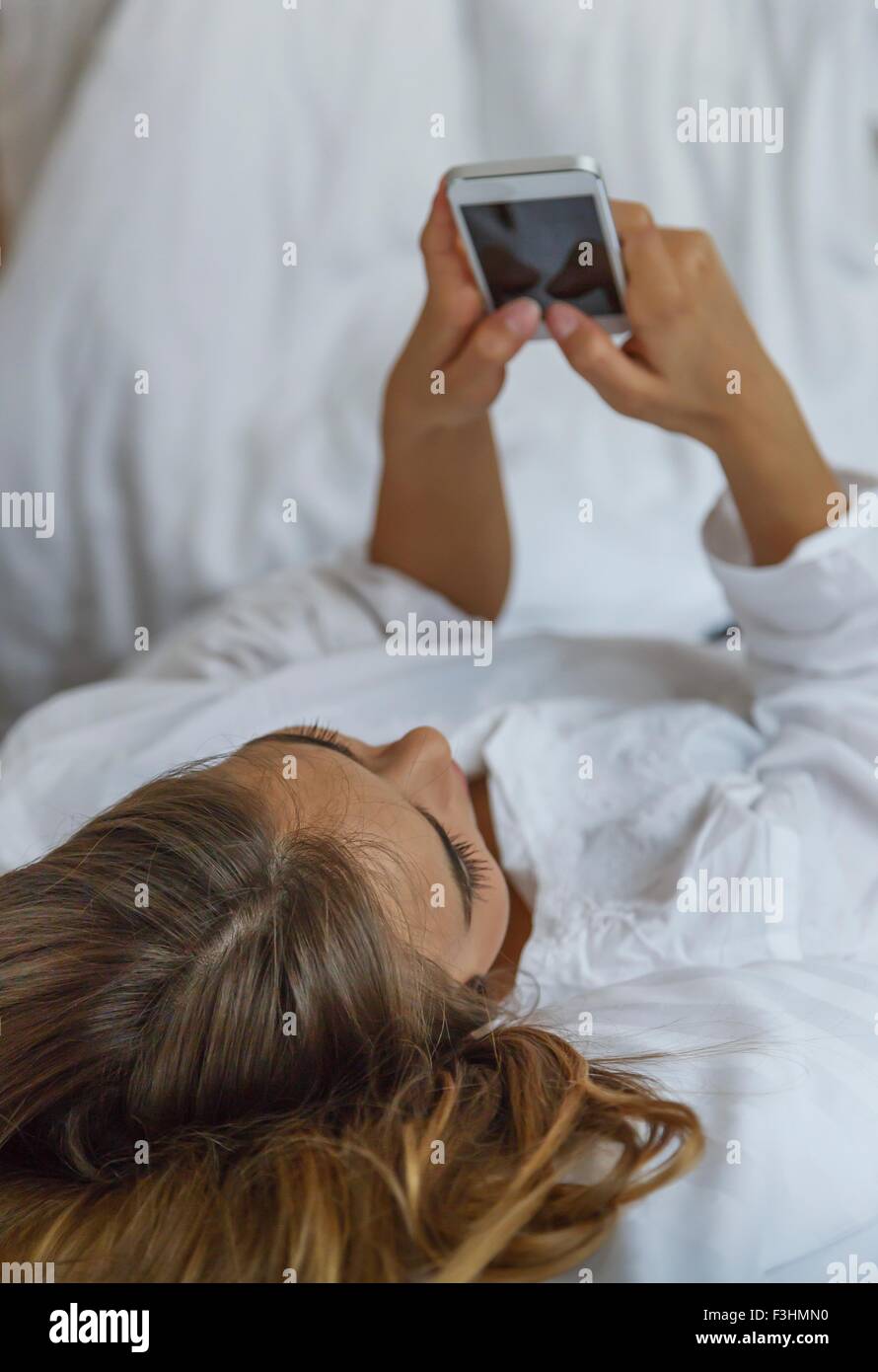 Hohen Winkel über Schulter Blick der jungen Frau mit smartphone Stockfoto