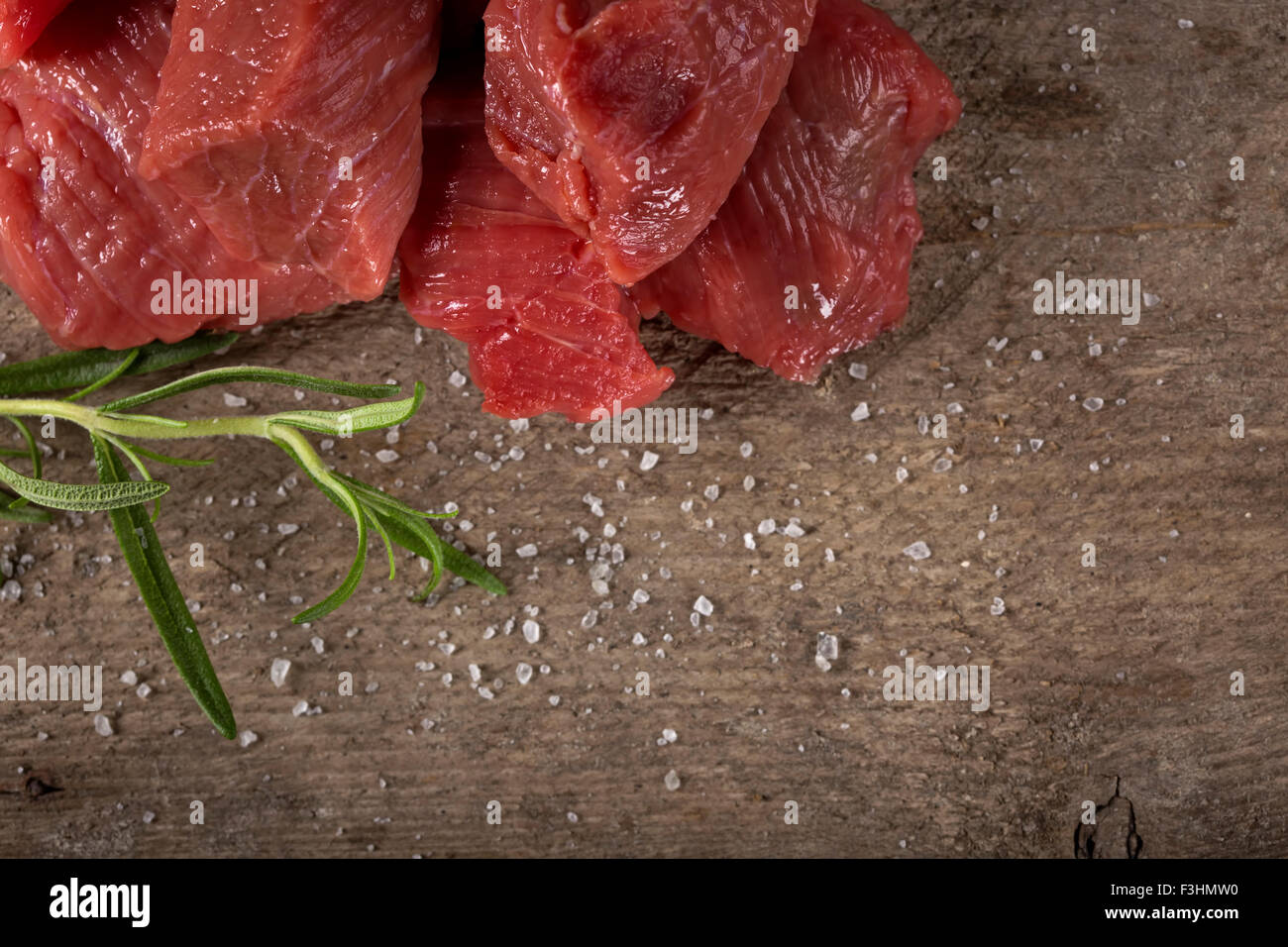 Rohes Rindfleisch mit Gewürzen auf Holz Hintergrund mit Textfreiraum Stockfoto
