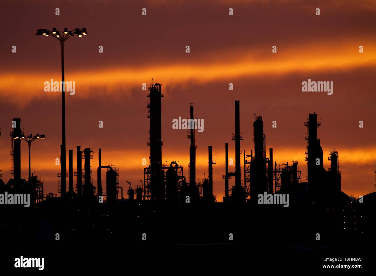 Öl-Raffinerie bei Sonnenuntergang mit dramatischer Himmel Stockfoto