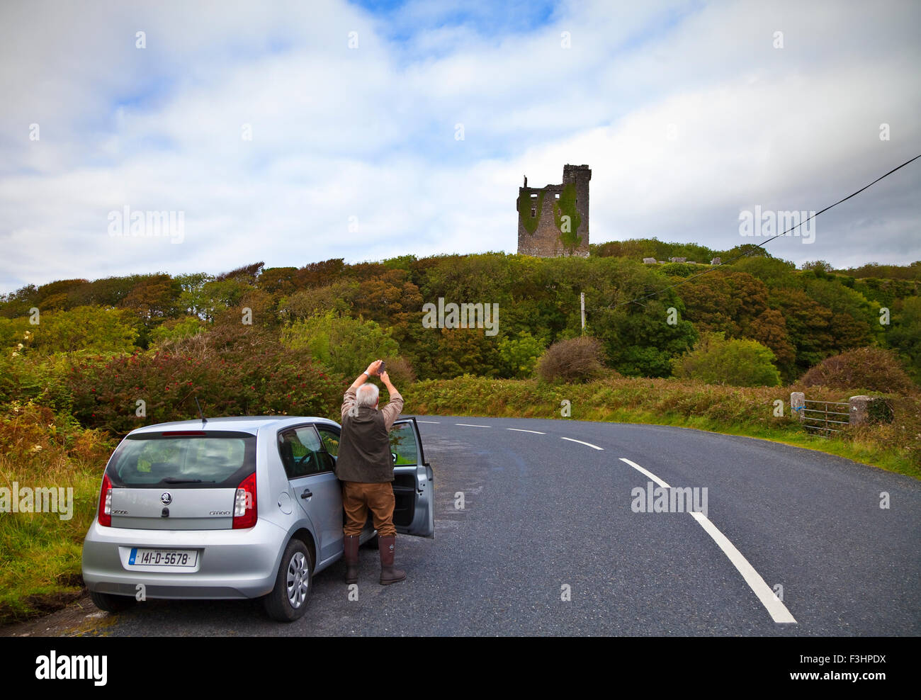 Ältere Touristen fotografieren aus dem 16. Jahrhundert Ballinalacken Burg Burren, zwischen Lisdoonvarna und Fanore, County Clare, Irland Stockfoto
