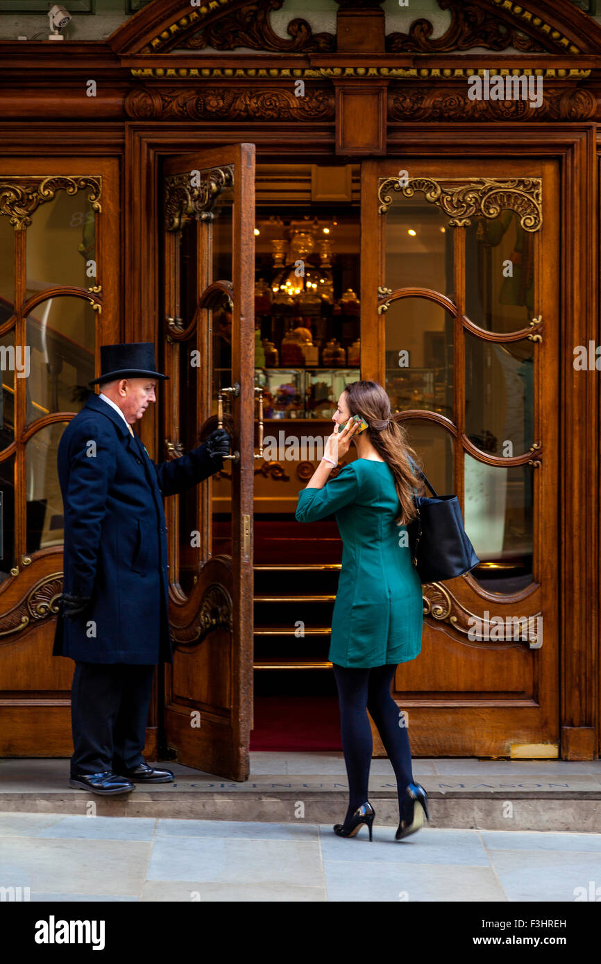 Portier am Eingang zu Fortnum and Mason Department Store öffnet die Tür für Kunden, London, UK Stockfoto