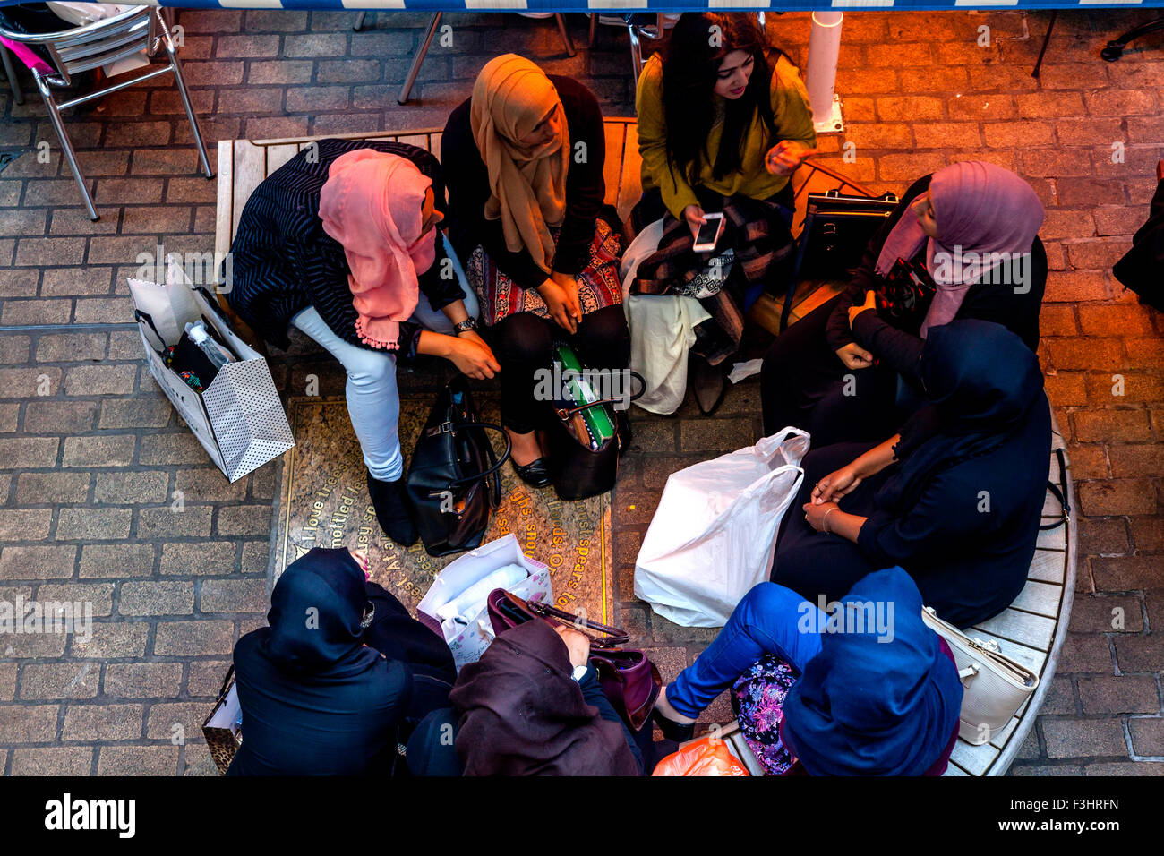 Junge muslimische Frauen sitzen im Chat auf ein Cafe In der Carnaby Street, London, UK Stockfoto