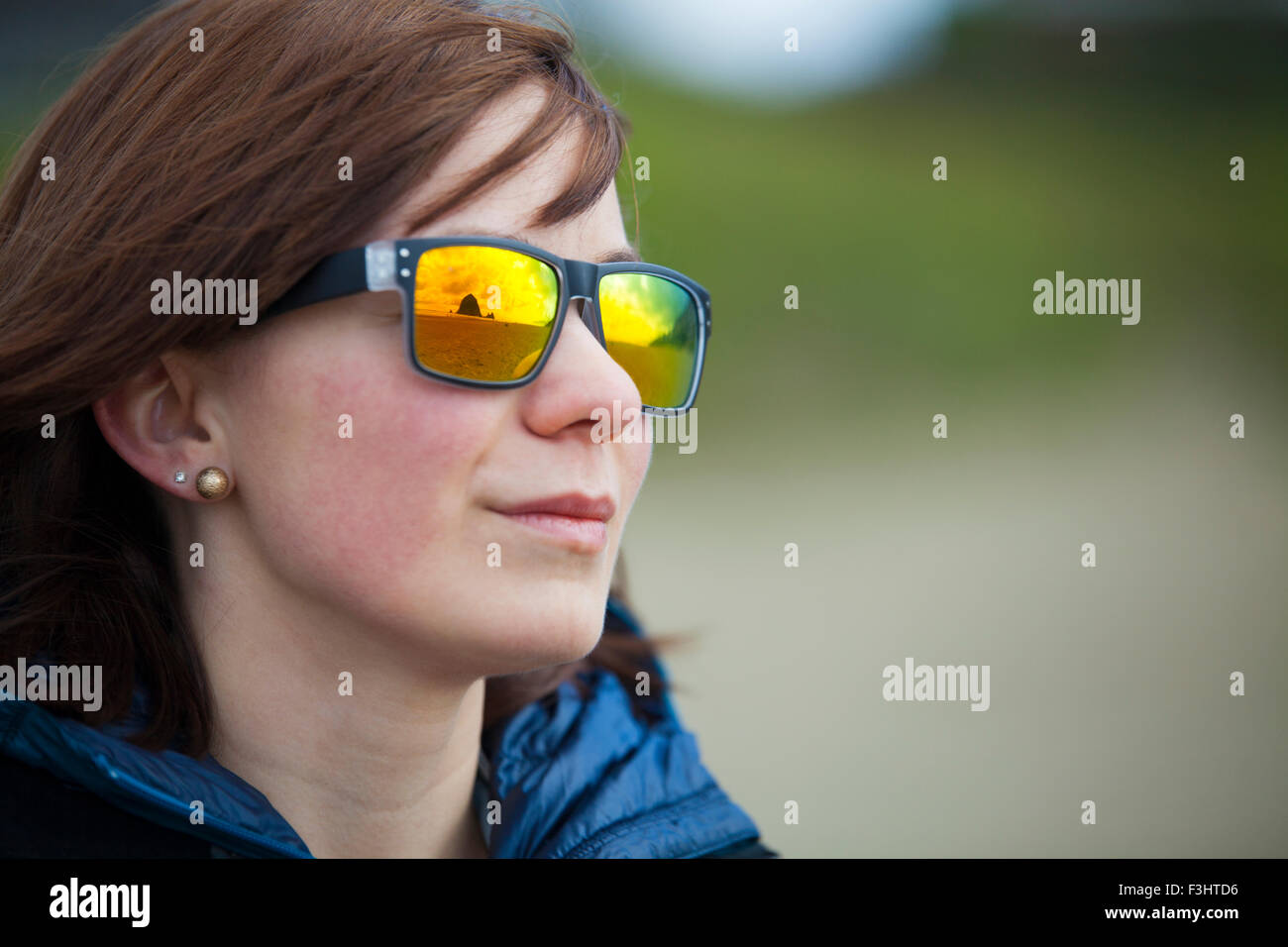 Haystack Rock und Cannon Beach spiegelt sich in eine junge Womans bunte Sonnenbrillen. Stockfoto