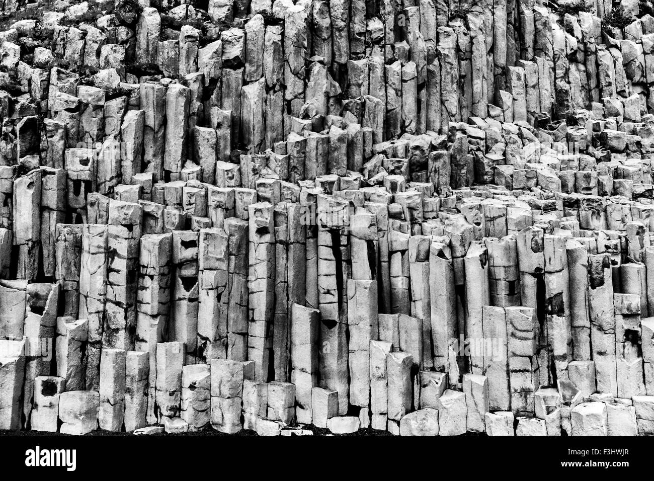 Basalt geometrische Spalte Felsformationen am schwarzen vulkanischen Kirkjufjara Sandstrand in der Nähe von Vik, Island Stockfoto