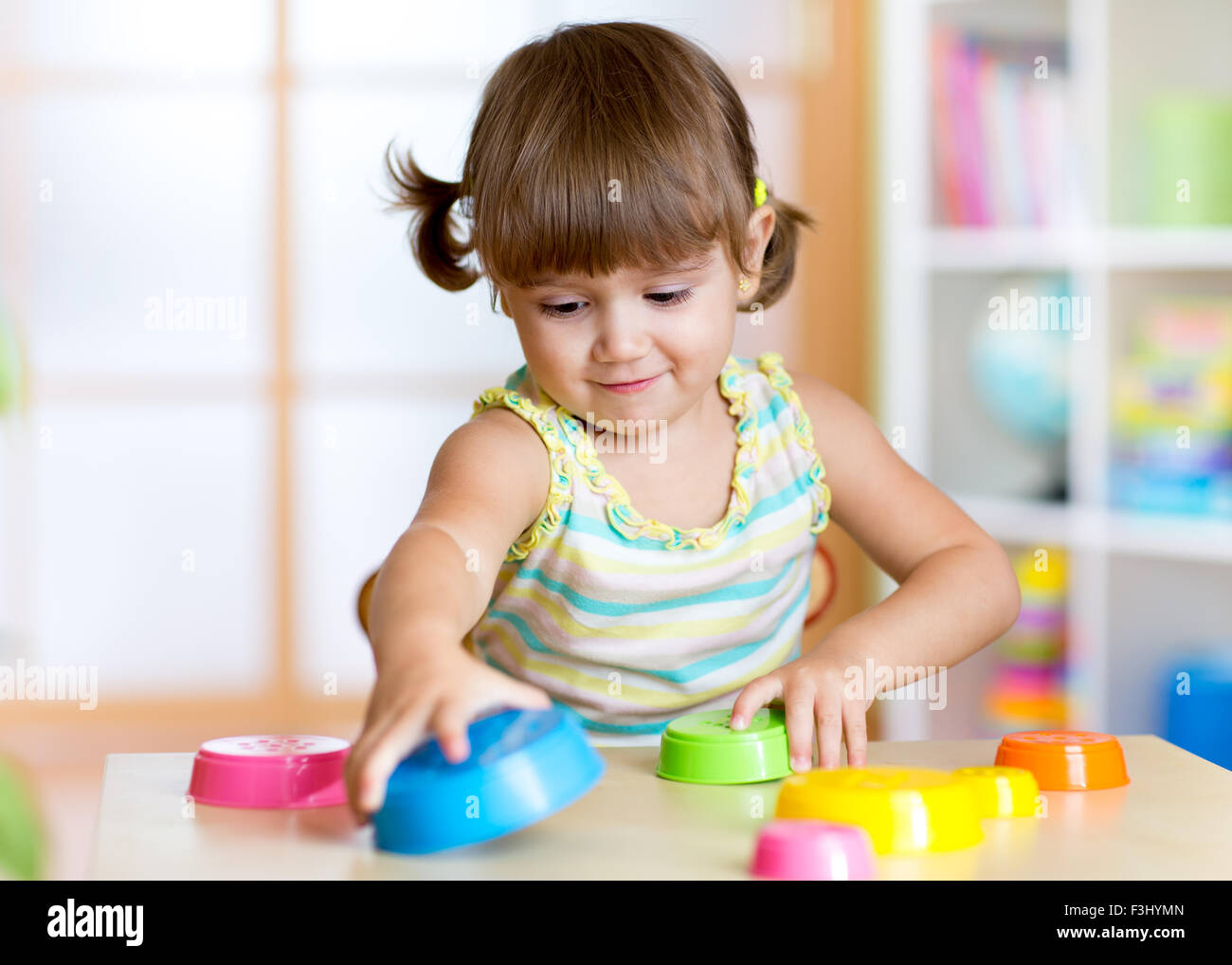 junge Mädchen spielen mit Spielzeug drinnen Stockfoto