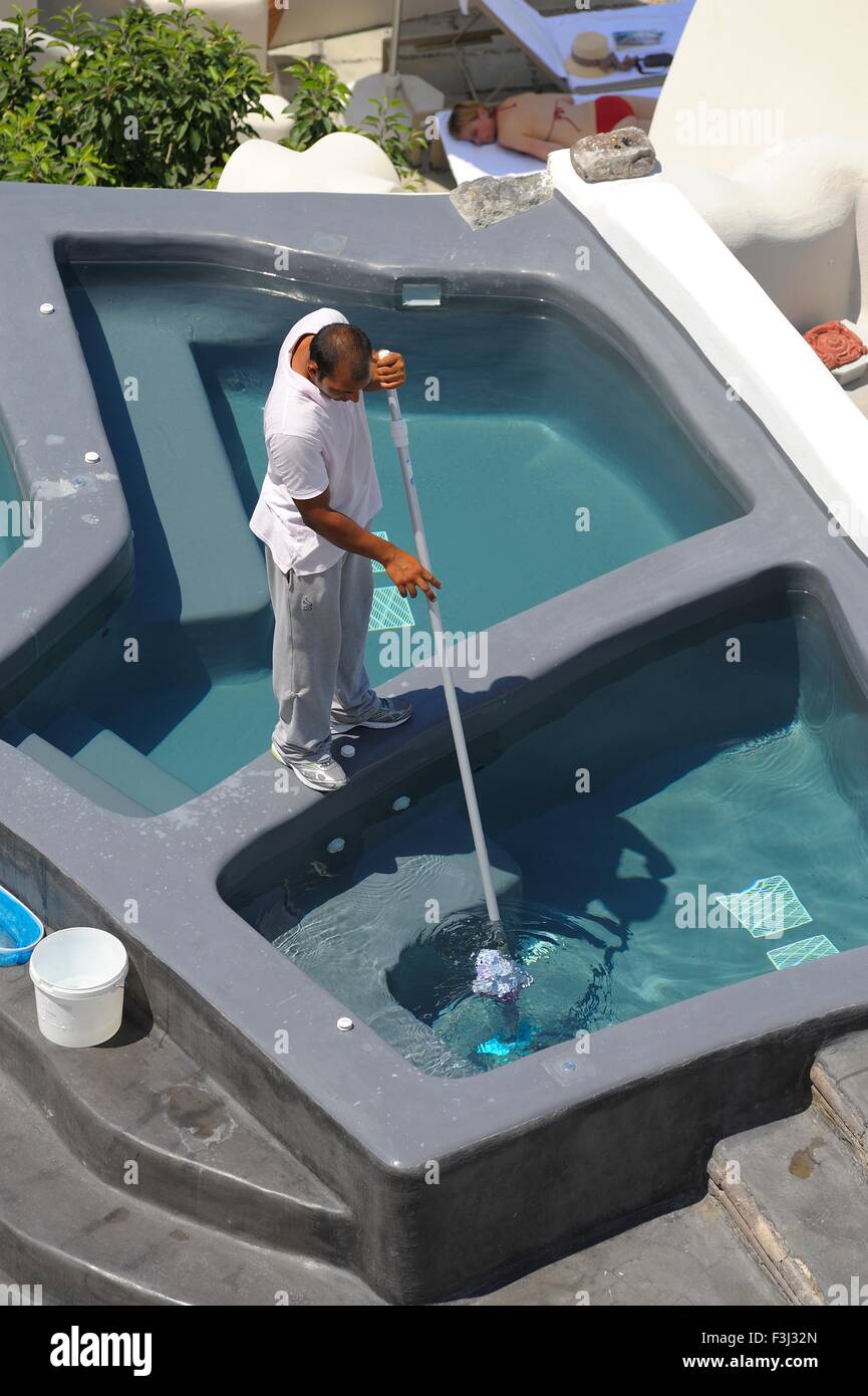 Ein Hotel-Arbeiter mit einem Kokido Skooba Vac einige Tauchbecken auf der Insel Santorini Griechenland sauber Stockfoto