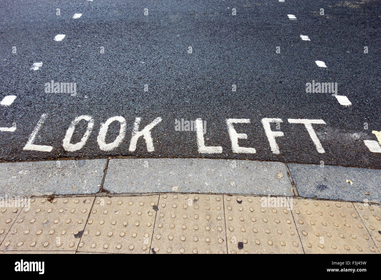 Schauen Sie links Warnung an einem Fußgängerüberweg in einer Londoner Straße. Stockfoto