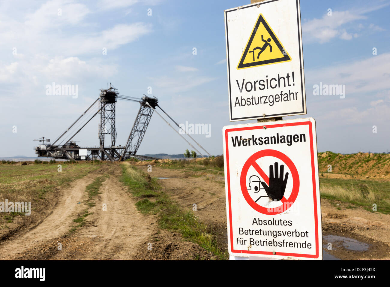 Warnschild in der Nähe von einem riesigen Mining-Bagger im Tagebau in der Nähe von Köln. Stockfoto