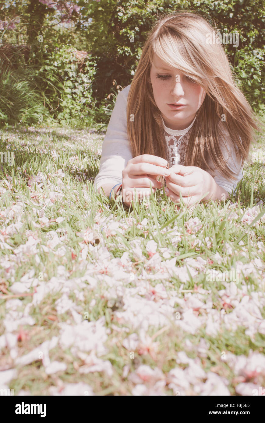 Junge blonde Teenager-Mädchen in Kirschblüte Stockfoto