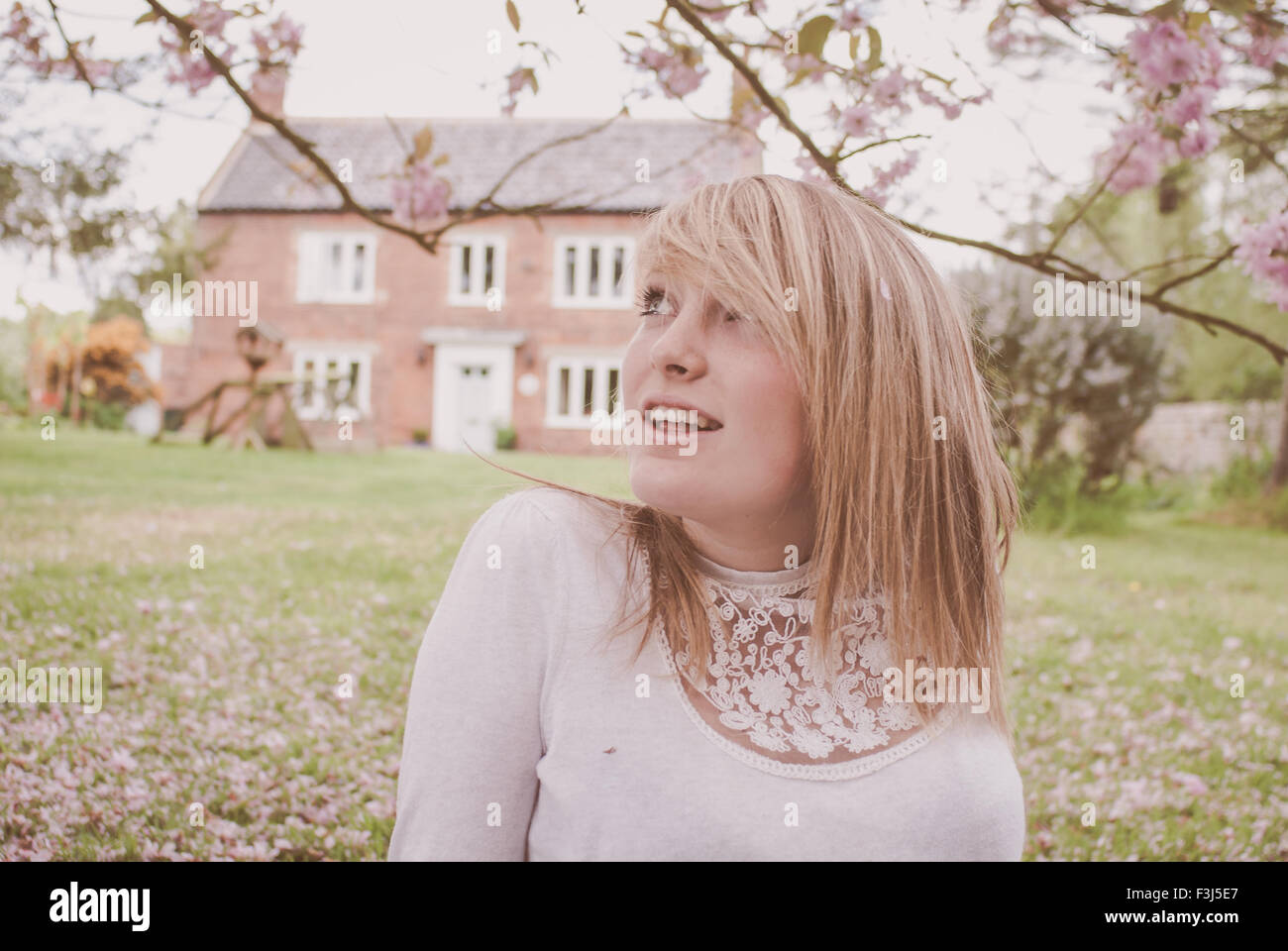 Junge blonde Teenager-Mädchen in Kirschblüte Stockfoto