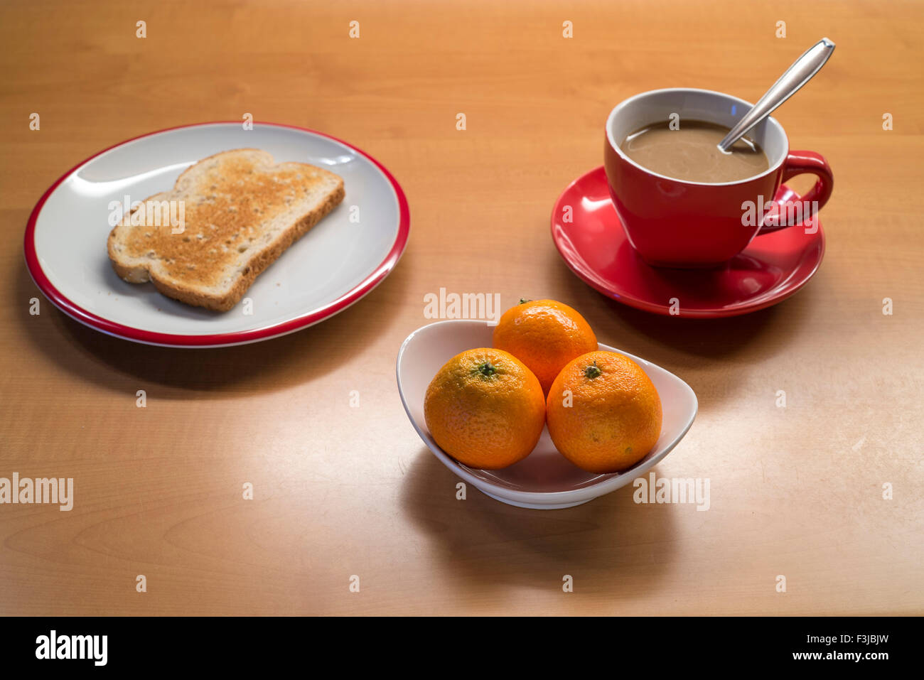 Mediterranes Frühstück: Kaffee mit Milch, Obst und Toast Stockfoto