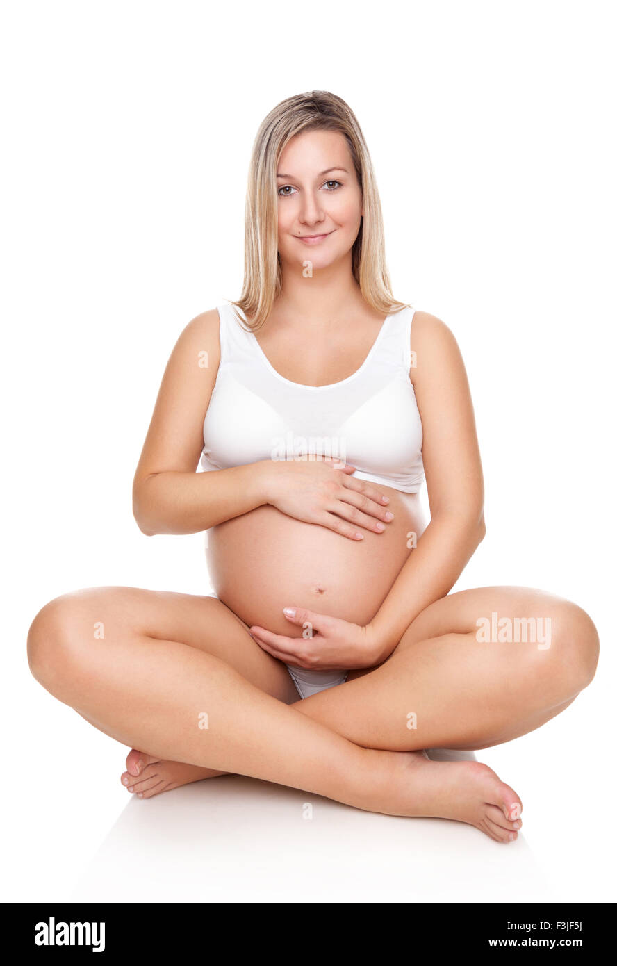 Porträt einer glücklich schwanger Frau sitzt auf dem Boden und halten Bauch Stockfoto