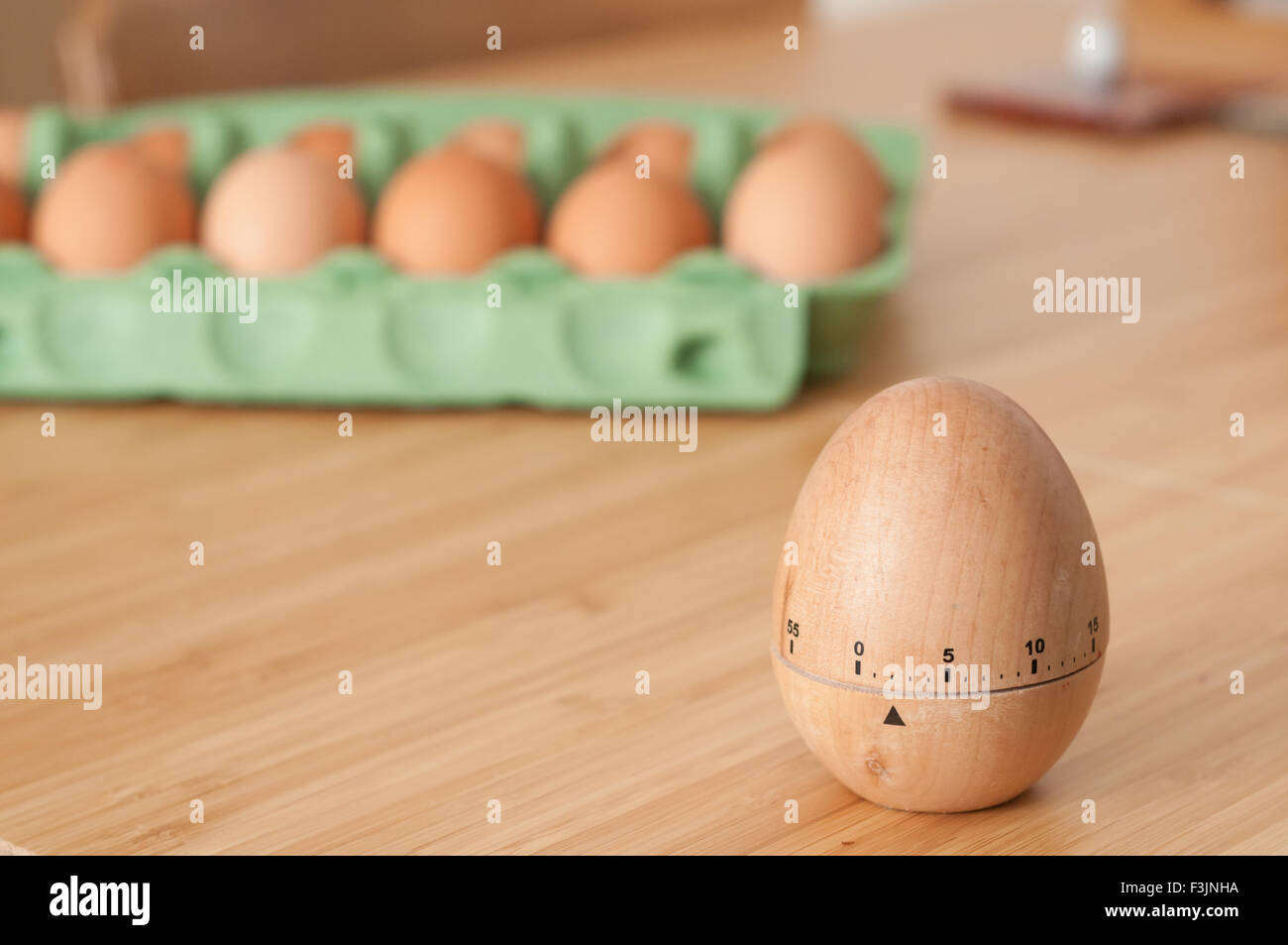 Eieruhr mit einem Karton von frischen Eiern im Hintergrund Stockfoto