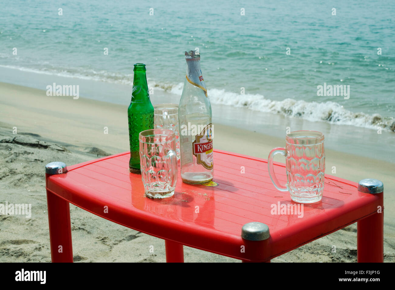 leere Bierflasche und Tassen auf Kunststoff Tisch am Strand von Devbaug Sindhudurgh; Maharashtra; Indien Stockfoto