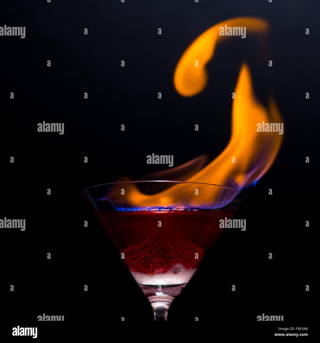 Feuer, weht aus Martini Glas/close-up mit schwarzem Hintergrund Stockfoto