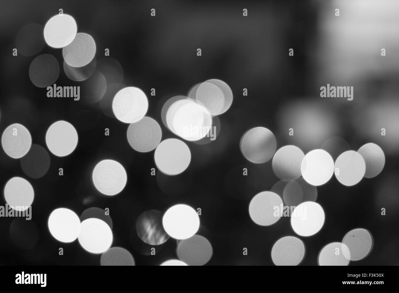 Erstellt durch eine Reihe von schwarzen und weißen Bokeh Hintergrund unscharf gestellt Weihnachtsbeleuchtung. Stockfoto
