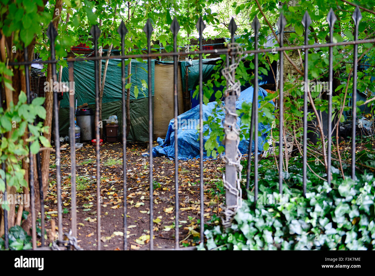 Obdachlose in Großbritannien leben mit Zelt und semi-permanent-planen versteckt unter Bäumen hinter Eisengitter, Bristol England Stockfoto