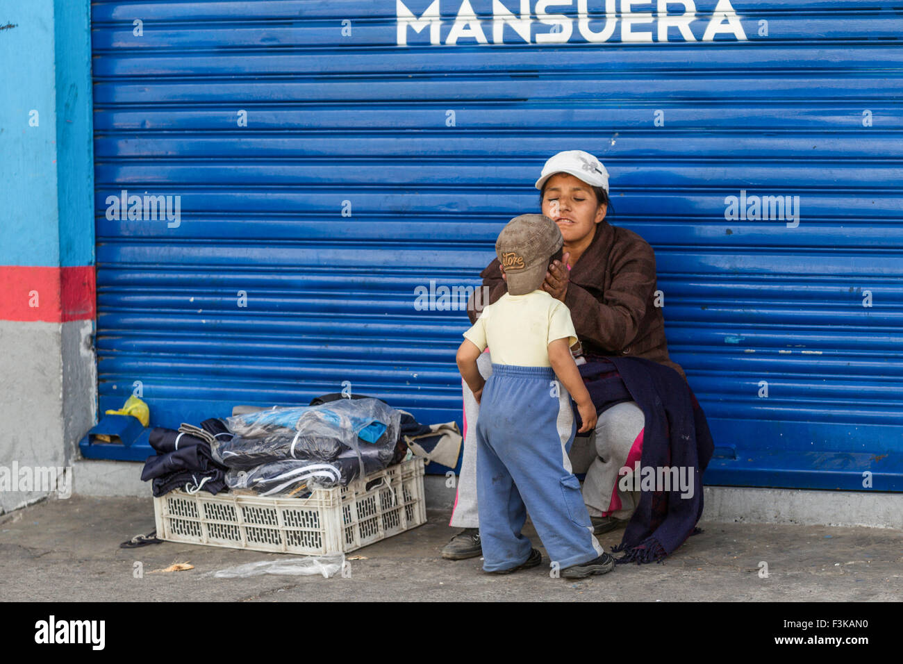 Emotionaler Moment mit einem Straße Verkäufer Frau die Aufmerksamkeit auf ihren kleinen Sohn Stockfoto