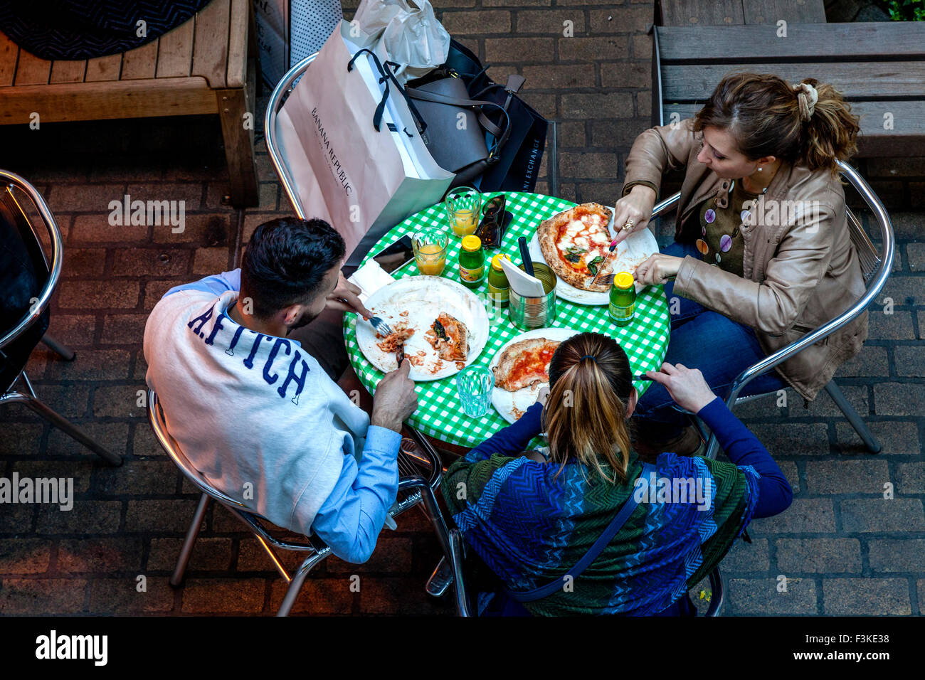 Touristen essen Pizza am königlichen Gericht von Carnaby Street, London, UK Stockfoto