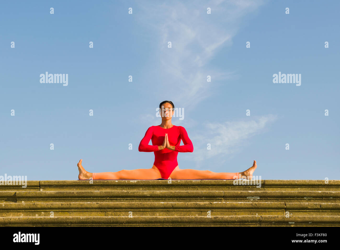 Junge Frau, tragen eine rot-orange Babybody, übt Hatha-yoga Outdoor, zeigt die Pose: samakonasana, rightanglepose/ Stockfoto