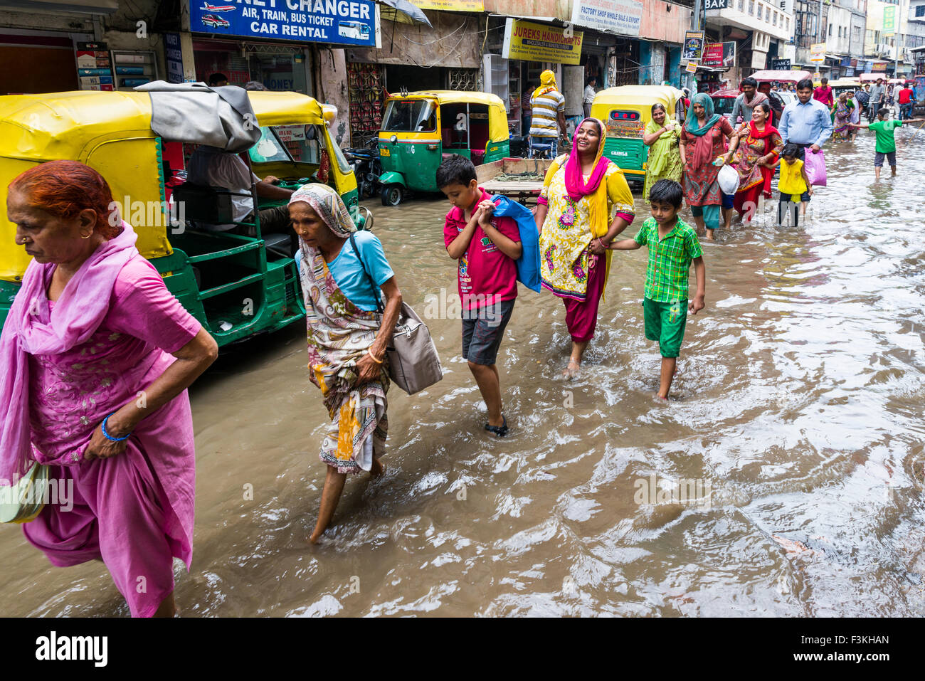 Viele Menschen und Zyklus Rikschas sind durch die überschwemmten Straßen der Vorstadt paharganj nach einem heftigen Monsun-regen Stockfoto