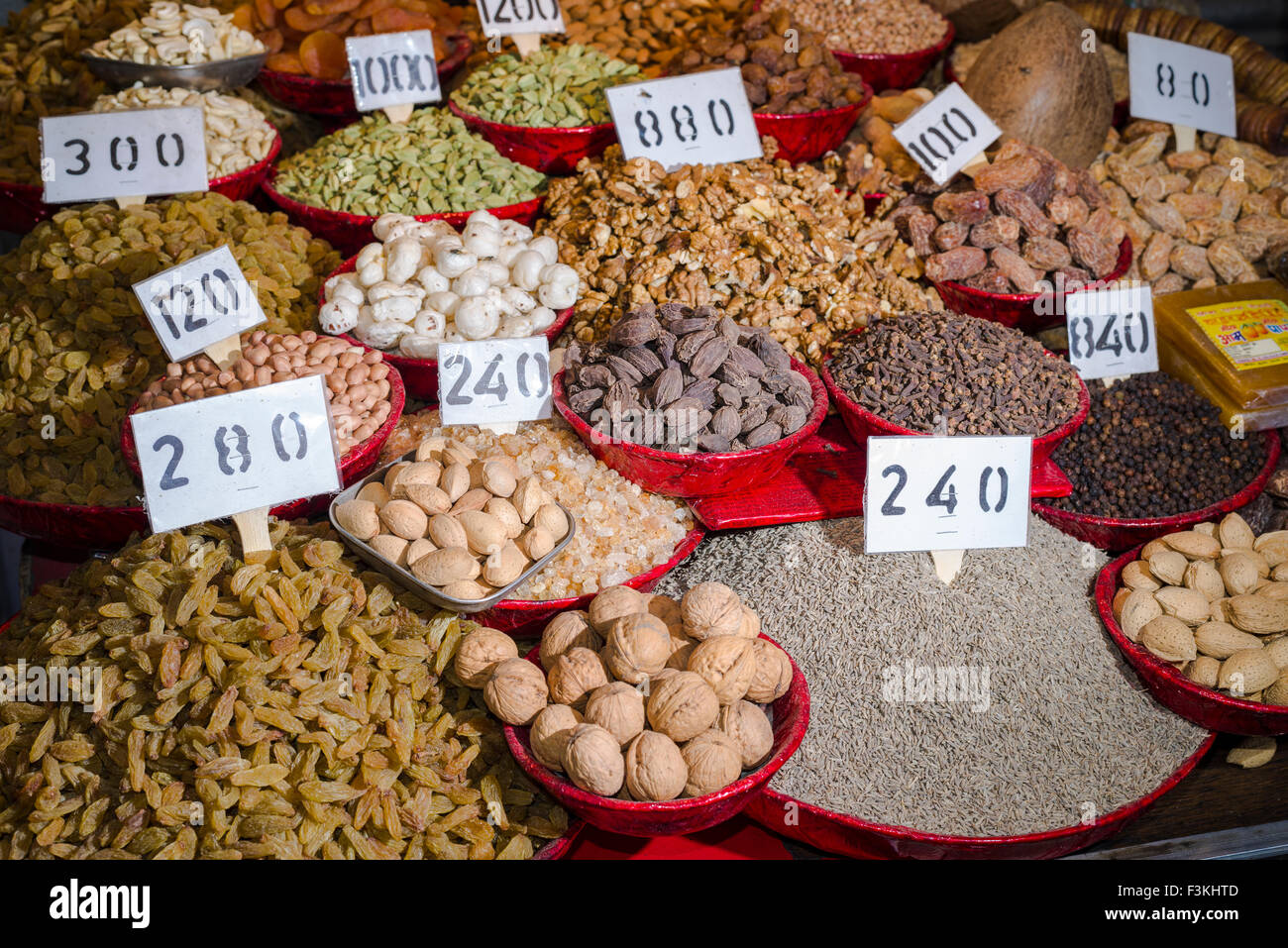 Termine, Walnüsse, Rosinen, Nelken, Kümmel, schwarzer Pfeffer und Kardamom sind in Schalen im alten Delhi Spice Market angezeigt Stockfoto