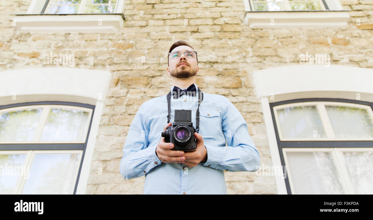 glückliche junge Hipster Mann mit Filmkamera in Stadt Stockfoto