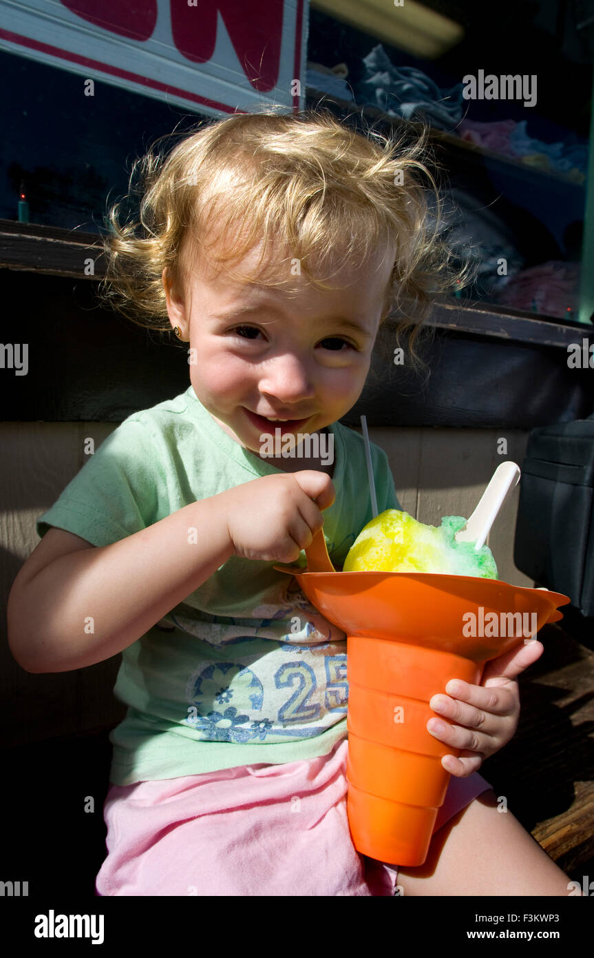 Kind in der Shop Matsumoto Shave Ice Haleiwa Eis essen. O' ahu. Hawaii. Aromatisiertes Wassereis von Matsumoto Lebensmittelgeschäft St Stockfoto