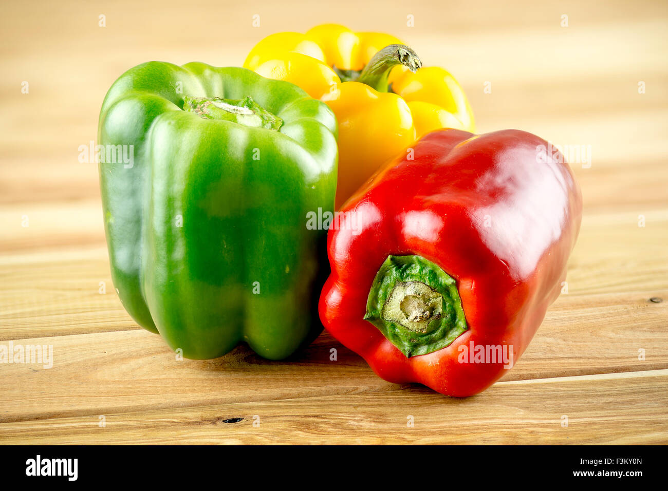 Rote gelbe und grüne Paprika auf hölzernen Hintergrund Stockfoto