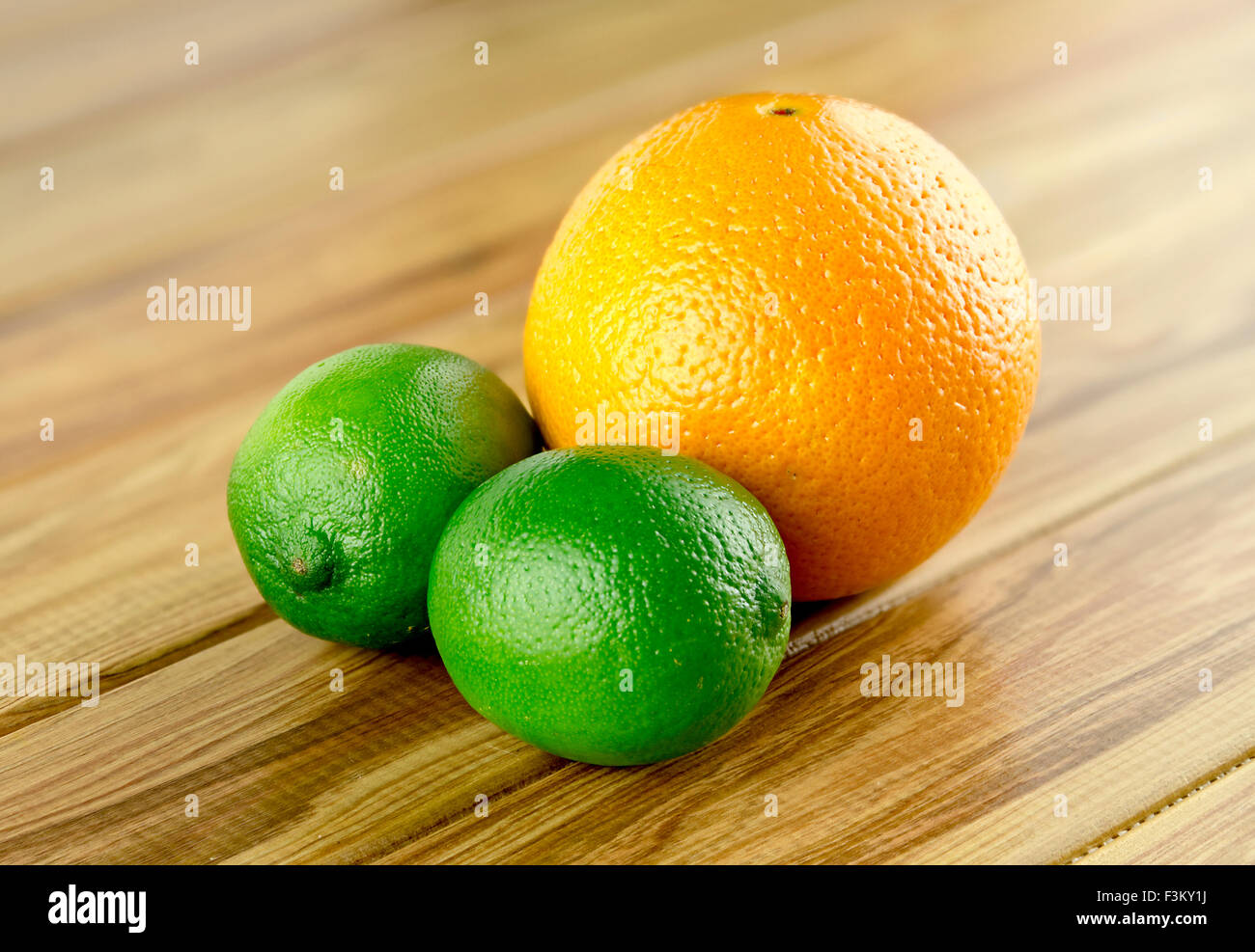 Zwei Limetten und eine Orange rustikalen Hintergrund Stockfoto