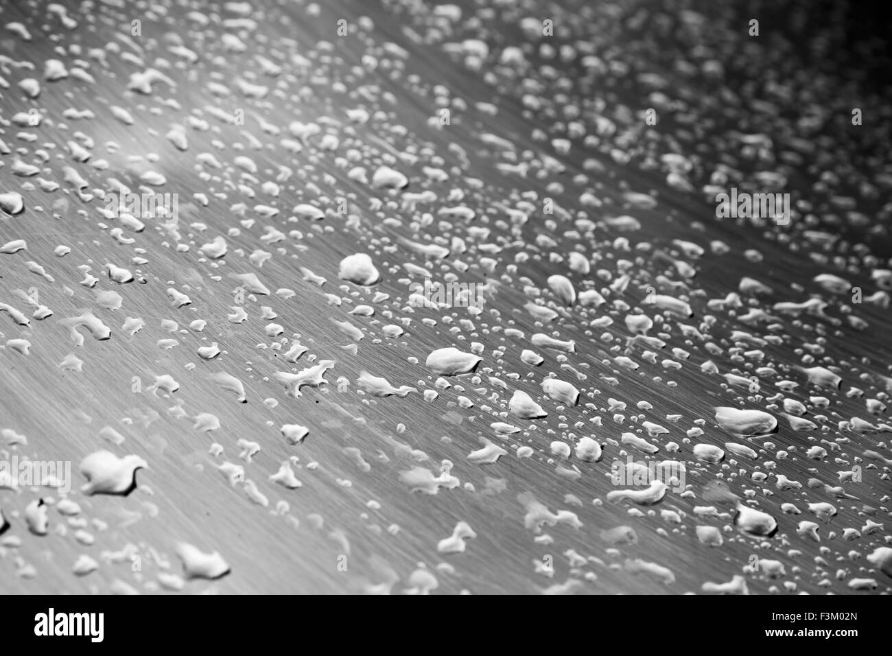 Edelstahl-Oberfläche mit Wasser Tropfen, monochrome Fotos mit Tiefenschärfe Stockfoto