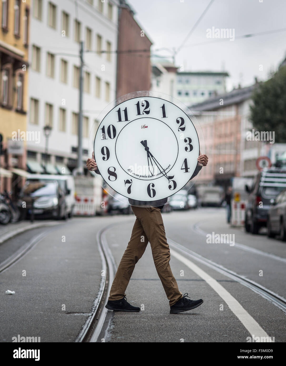 Frankfurt, Deutschland. 9. Oktober 2015. Younus Bouaoun, einer der wenigen  Uhr Maker Lehrlinge in Frankfurt am Main, trägt eine große Wanduhr in einer  Straße in Frankfurt, Deutschland, 9. Oktober 2015. Foto: Frank