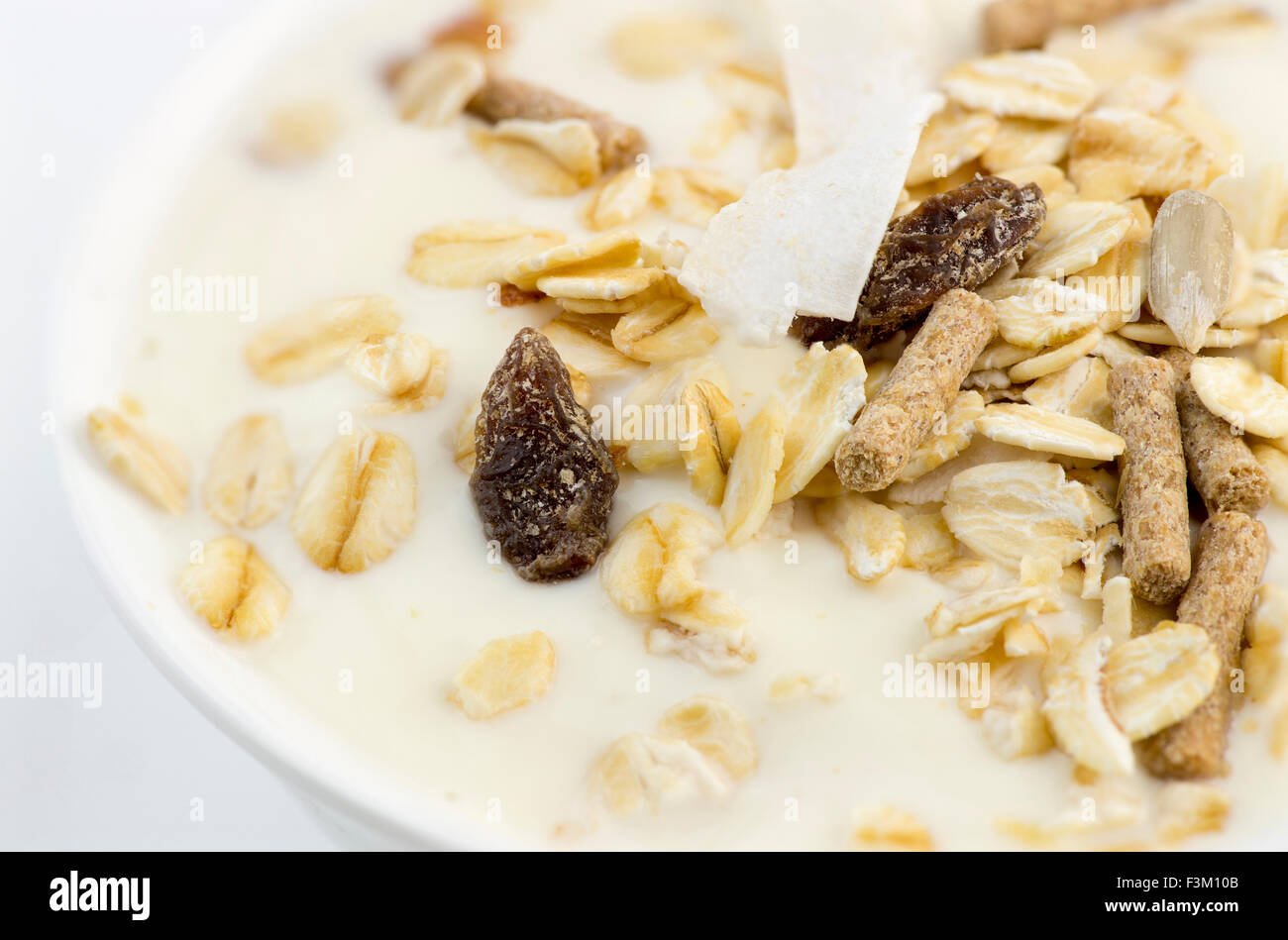Makro Nahaufnahme von köstlichen fettarmen Joghurt mit Hafer, Müsli, Kleie, Mandeln und getrockneten Früchten Stockfoto