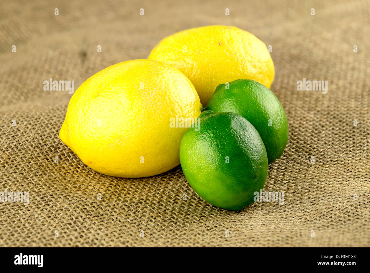 Zitronen und Limetten auf hessischen Hintergrund Stockfoto