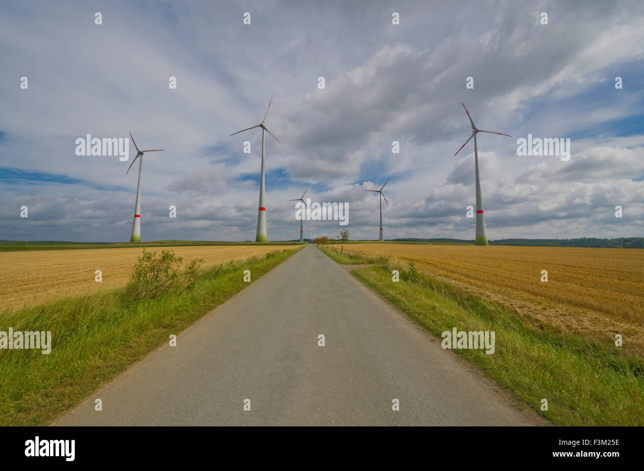 Einige Windkraftanlagen in landwirtschaftliche Landschaft mit blauen bewölkten Himmel Stockfoto