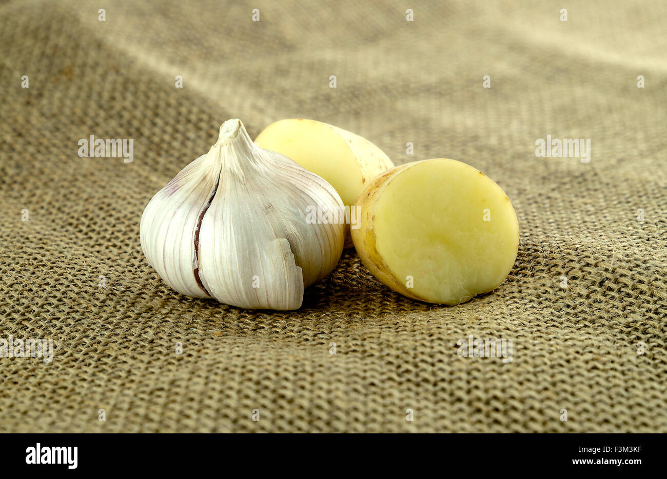 Knoblauch und geschnittene Kartoffel auf rustikalen hessische Landwirtschaft Blatt Stockfoto