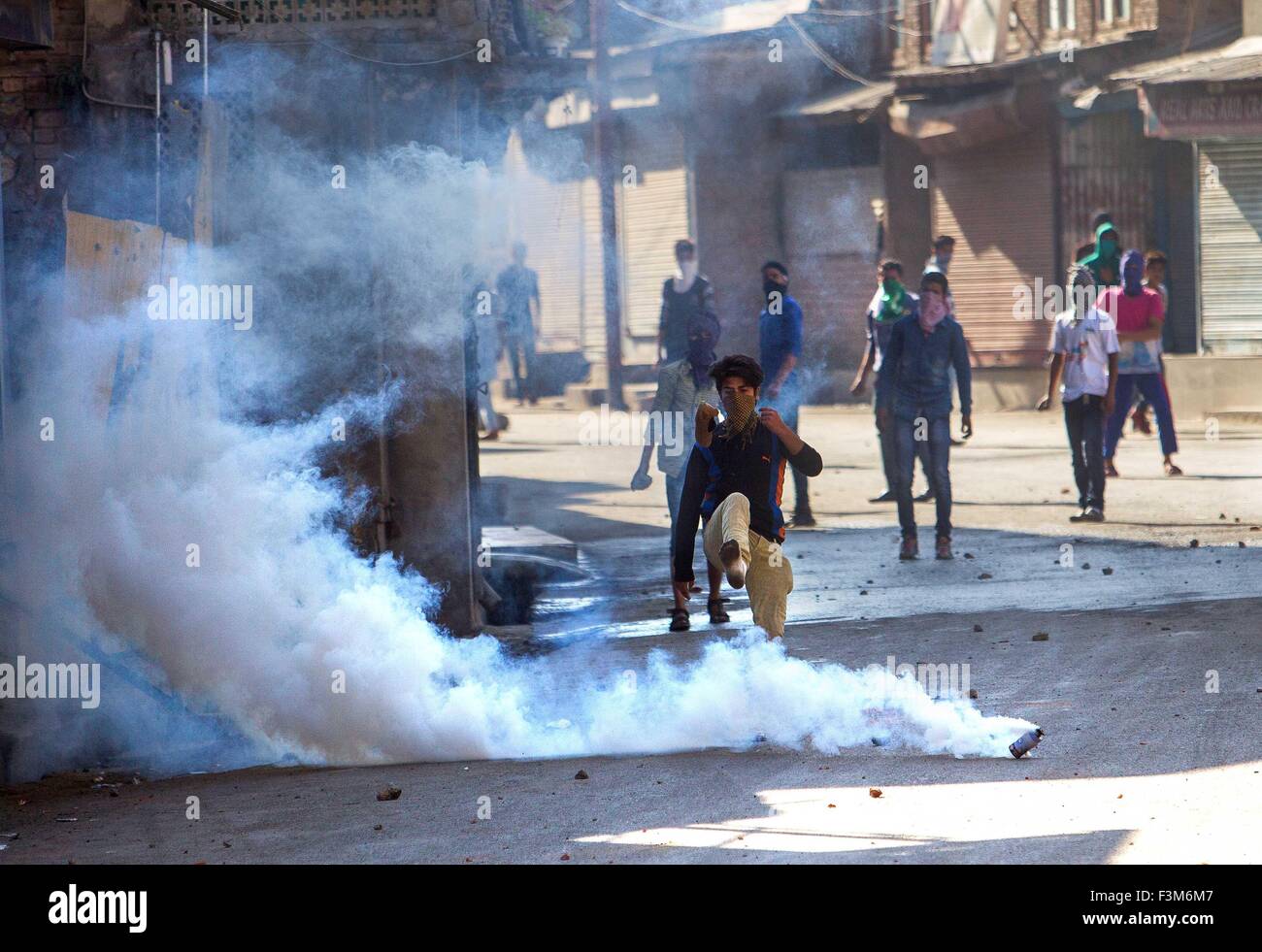 (151009)--SRINAGAR, 9. Oktober 2015 (Xinhua)--A Kashmiri Demonstrant (vorne) tritt eine Träne Rauch Shell abgefeuert von der indischen Polizei während einer Protestaktion in Srinagar, Sommer in der Hauptstadt von Indien kontrollierten Kaschmir, 9. Oktober 2015. Polizei feuerte Tränengas und Gummigeschossen Hunderte von Kashmiri Demonstranten zu zerstreuen, die gegen die Verhaftung von Kashmiri separatistischen Führungsbeamte und Jugendliche protestierten. Sie protestierten auch gegen angebliche Versuche der Indiens herrschenden rechten hinduistische nationalistische Bhartiya Janta Partei (BJP) und Völker Democratic Party (PDP) zu teilen Bewohner auf der Grundlage von Religion und Politik zu ersticken Stockfoto