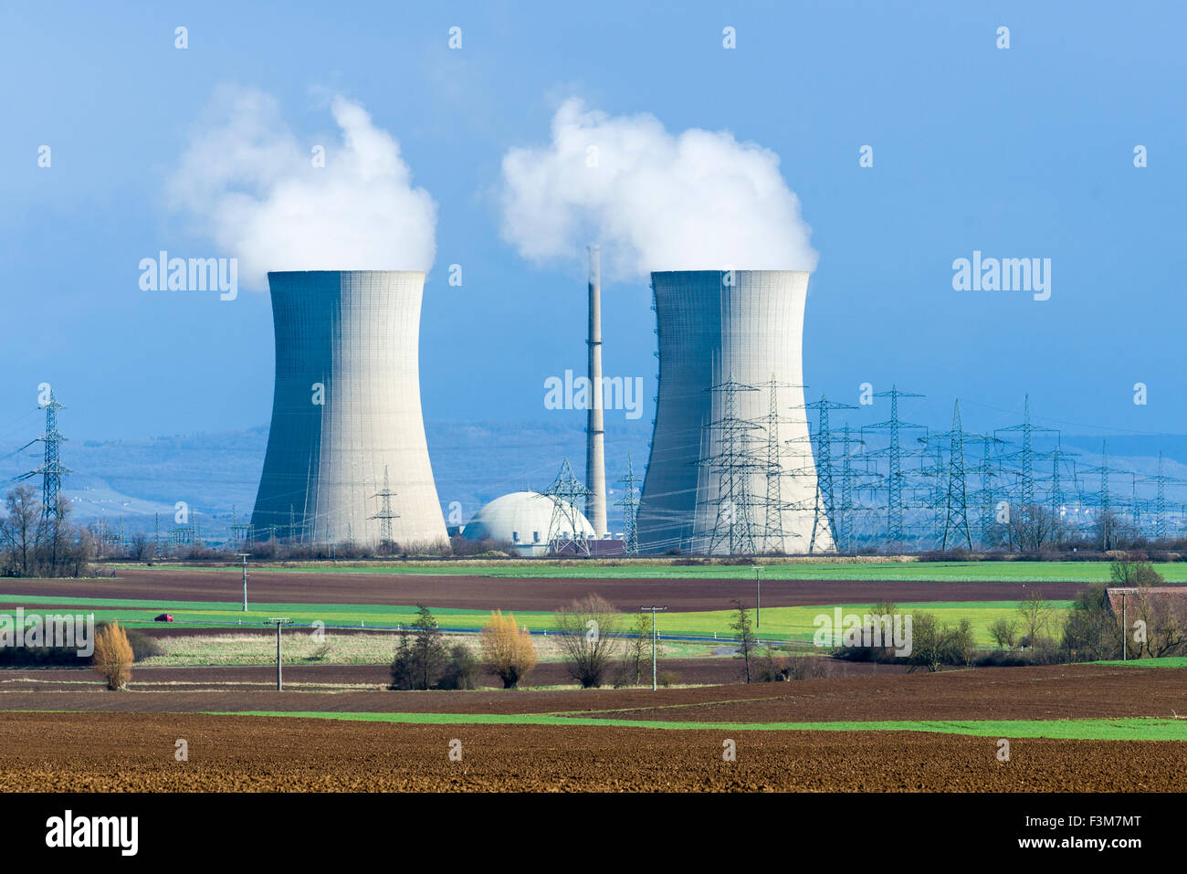 Die nuklearen Triebwerk grafenrheinfeld ist Dampf aus den Kühltürmen gegen dunkle Wolken, in landwirtschaftlichen landsc entfernt Stockfoto