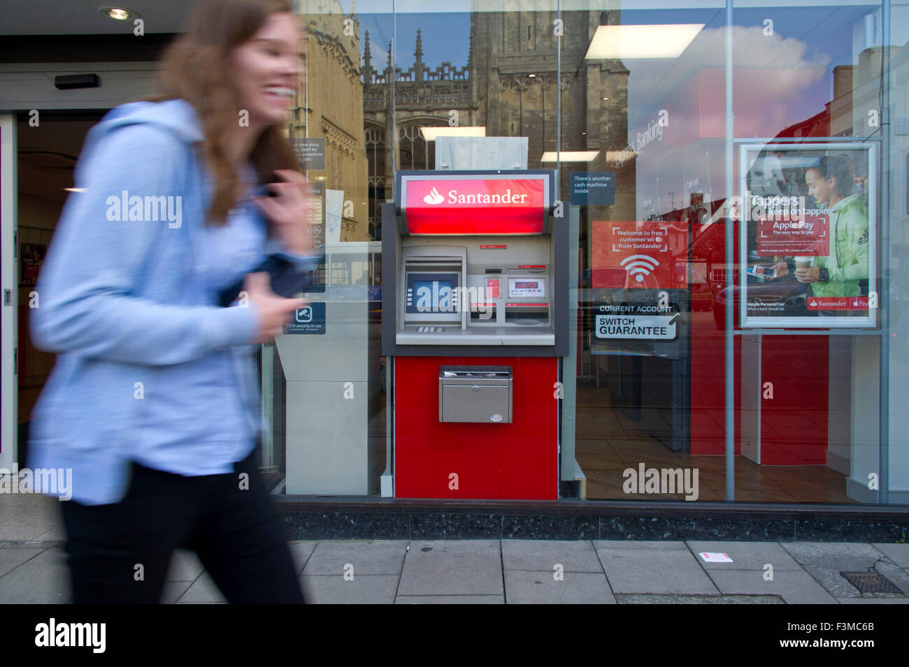 Ein Geldautomat Santander oder ATM in Urlaubsziele Stadt Hautpstraße beschäftigt Shopper eilen durch. eine UK Geld Cash Bank Finanzen Stockfoto