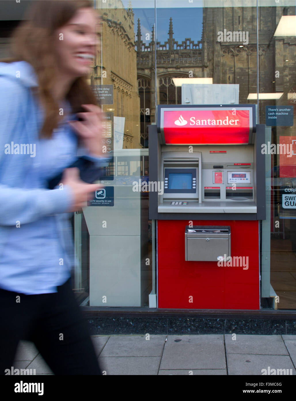 Ein Geldautomat Santander oder ATM in Urlaubsziele Stadt Hautpstraße beschäftigt Shopper eilen durch. eine UK Geld Cash Bank Finanzen Stockfoto