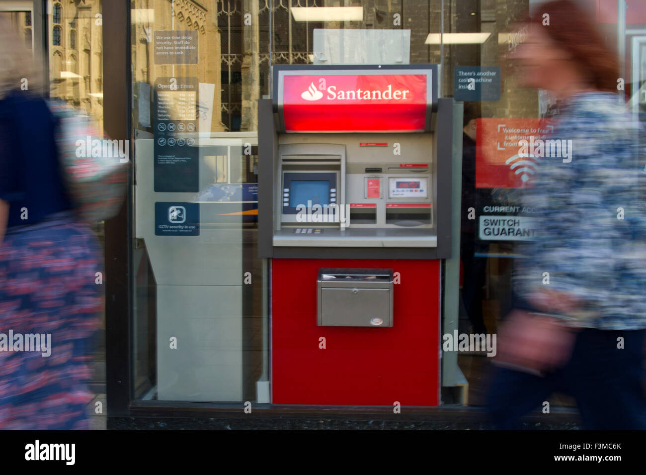 Ein Geldautomat Santander oder ATM in Urlaubsziele Stadt Hautpstraße beschäftigt Shopper eilen durch. eine UK Geld Cash Bank Finanzen Stockfoto