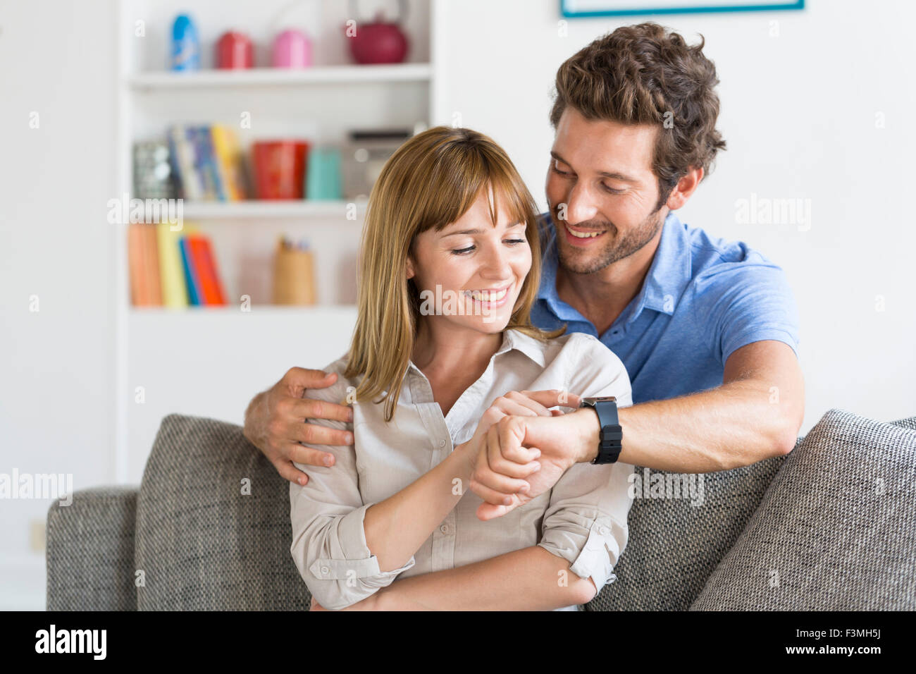 Man zeigt seine neue Smartwatch zu seiner Frau. Stockfoto