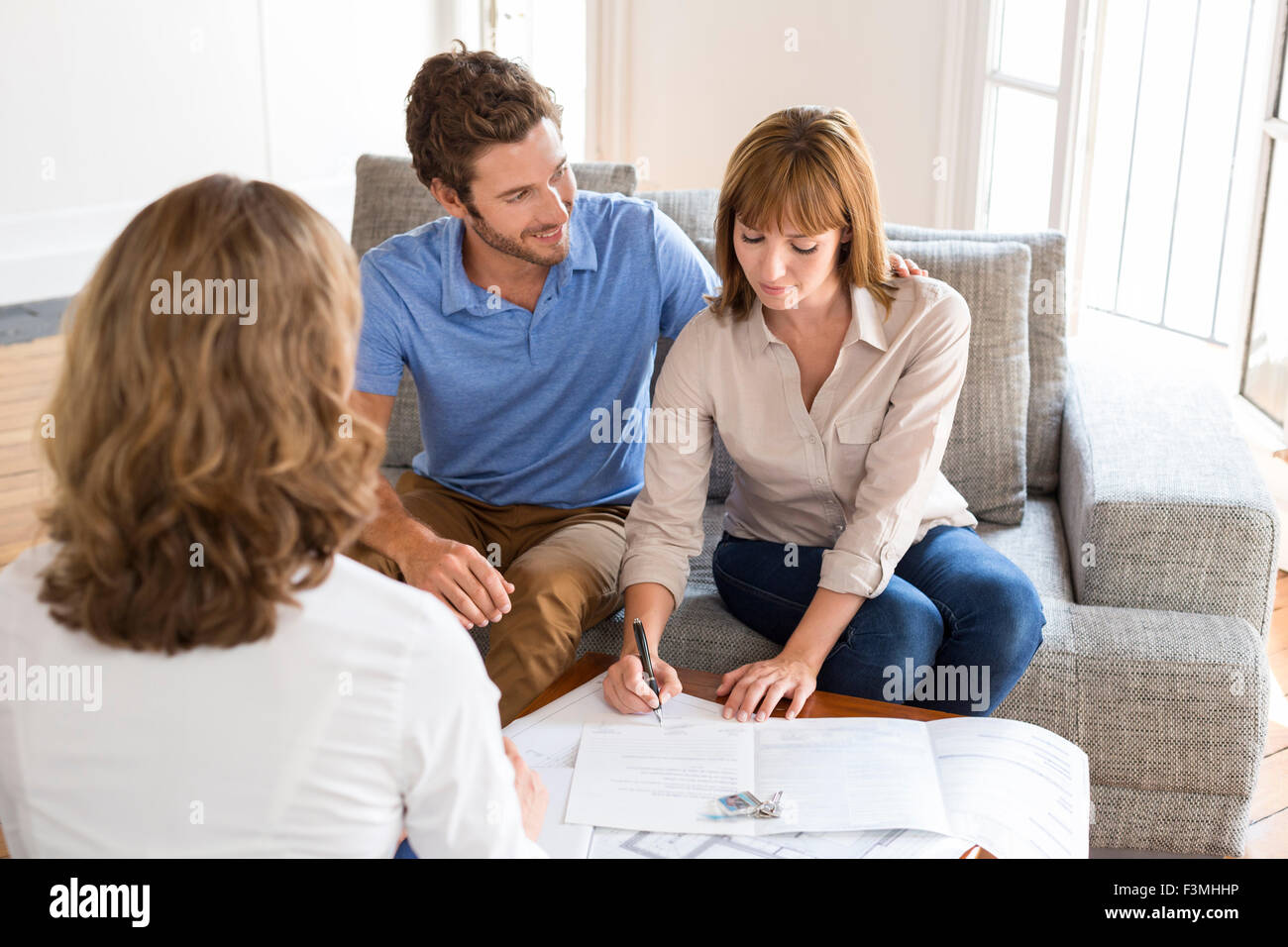 Junges Paar Besitzer Immobilienmakler für Haus-Investition zu treffen. Unterzeichnung eines Vertrages Stockfoto