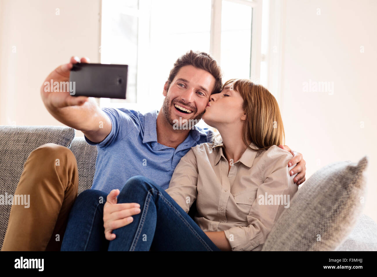 Paar in der Liebe, wobei ein Selbstporträt mit einem Mobiltelefon. Es macht ihm einen Kuss Stockfoto