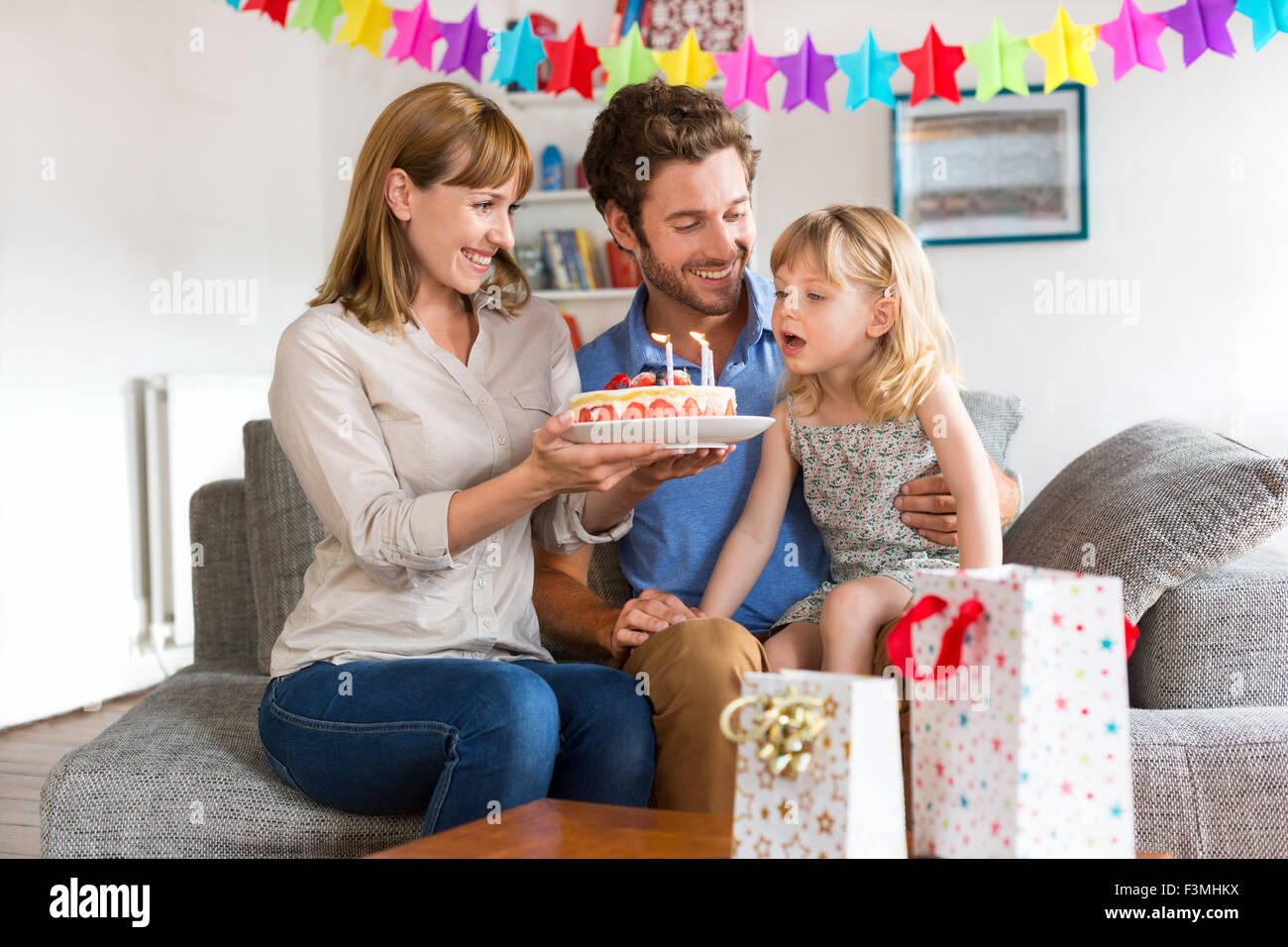 Kleine Mädchen feiert Geburtstagsparty in modernen Haus. Sie bläst die Kerzen Stockfoto