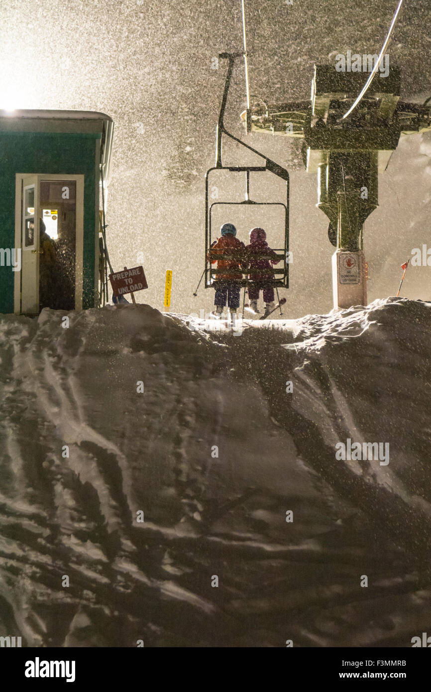 Zwei Mädchen reiten Ski heben beim Nachtskilauf, Silverton, Colorado. Stockfoto