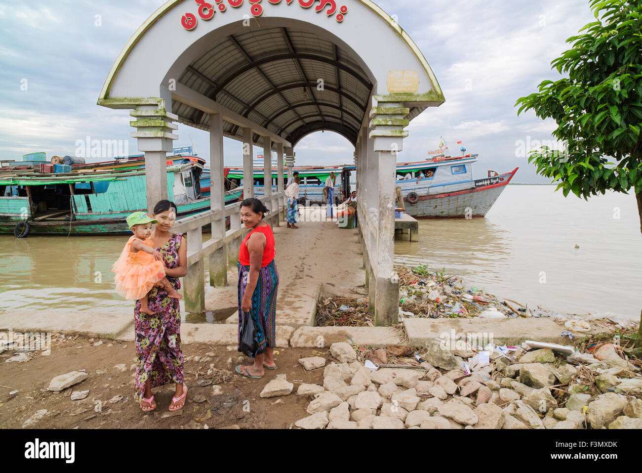 Junge Mutter und ihre Tochter an der Fähranlegestelle am YWir Fluß in Labutta Township, eine Stadt in der Ayeyarwady Division von Myanmar. Stockfoto