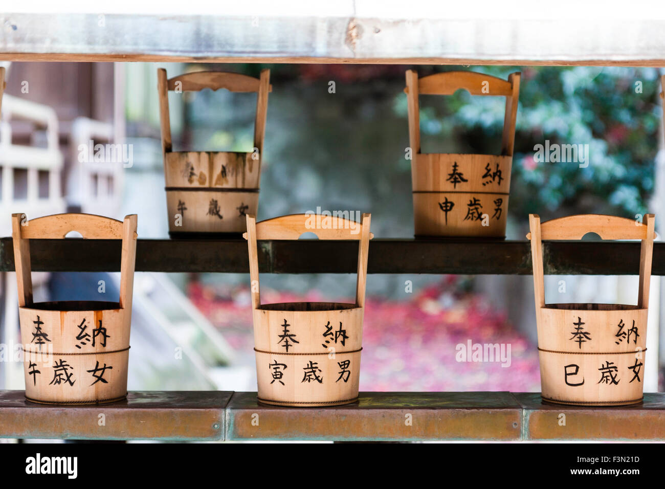 Kobe, Japan Shinto Schrein, Schöpflöffel, kleine Eimer durch die Wasseraufbereitung Brunnen benutzt, um Wasser zu sammeln, über die Hände zu gießen bei einem Besuch in einem Schrein. Stockfoto